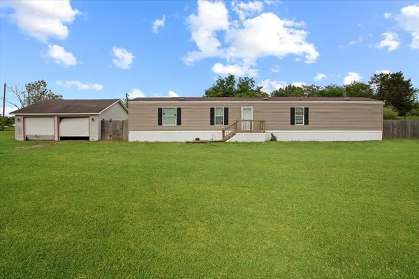 a front view of a house with a yard and trees