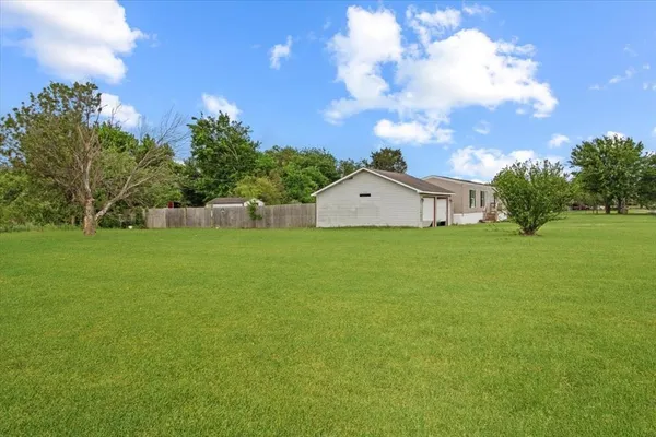 a view of a house with a big yard and garden