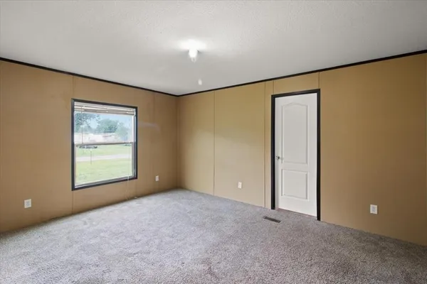 an empty room with windows and closet