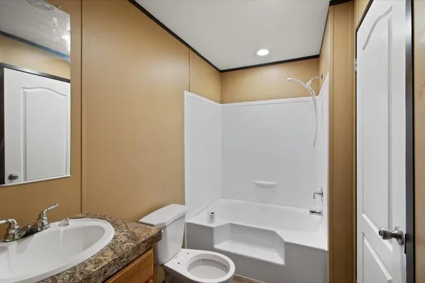 a bathroom with a granite countertop sink toilet and shower