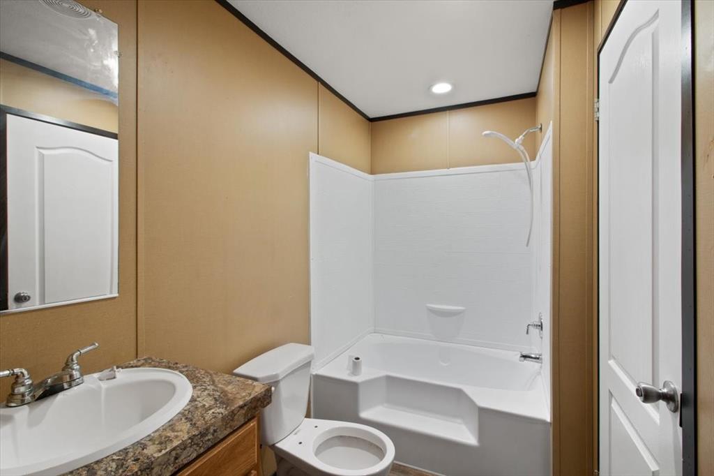 30 Galley Drive Denison, TX 75021 - Photo 7 of 18 a bathroom with a granite countertop sink toilet and shower