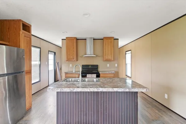 a kitchen with granite countertop a refrigerator and a stove top oven