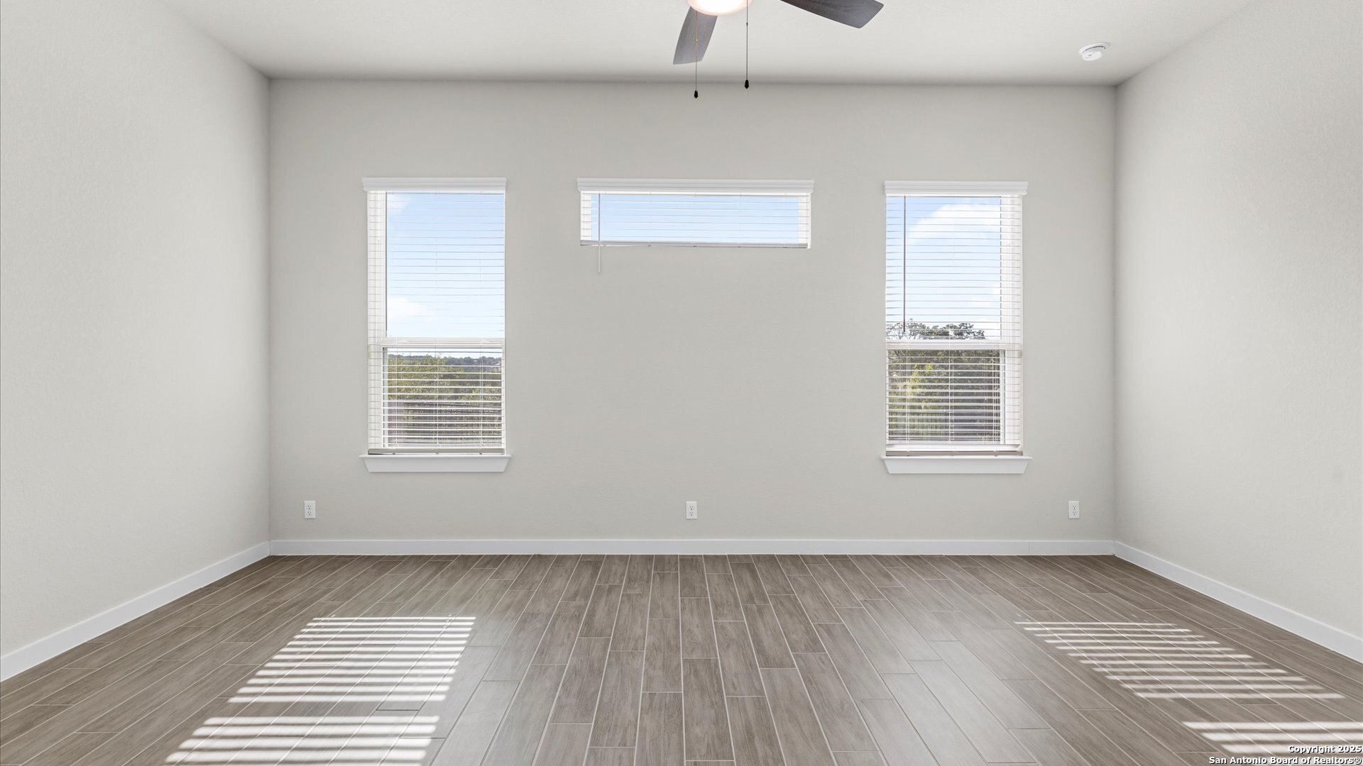 1551 Terrys Gate Road New Braunfels, TX 78132 - Photo 11 of 32 an empty room with wooden floor and windows