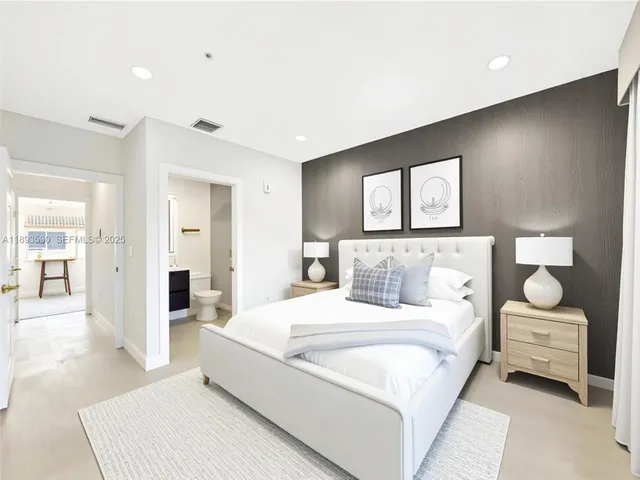 a bedroom with a large bed couch and painting on the wall