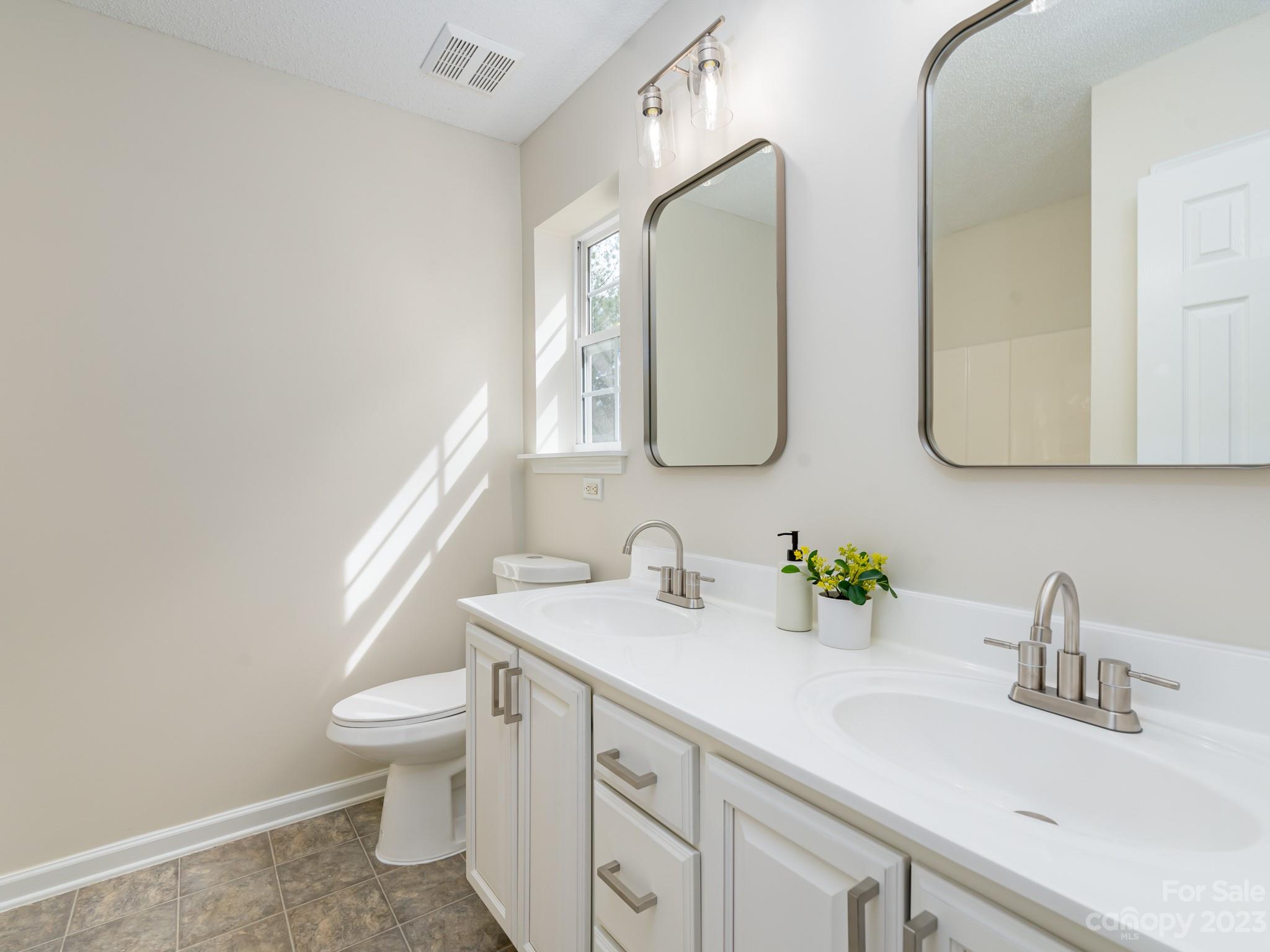 8158 Rudolph Road Charlotte, NC 28216 - Photo 15 of 23 a bathroom with a toilet sink and mirror