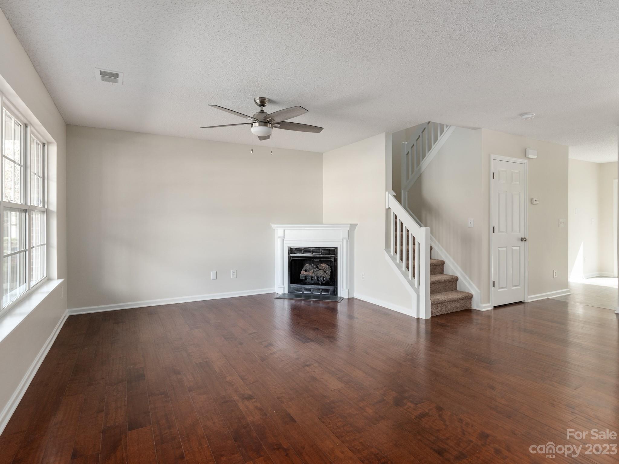 8158 Rudolph Road Charlotte, NC 28216 - Photo 2 of 23 a view of an empty room with wooden floor fireplace and a window