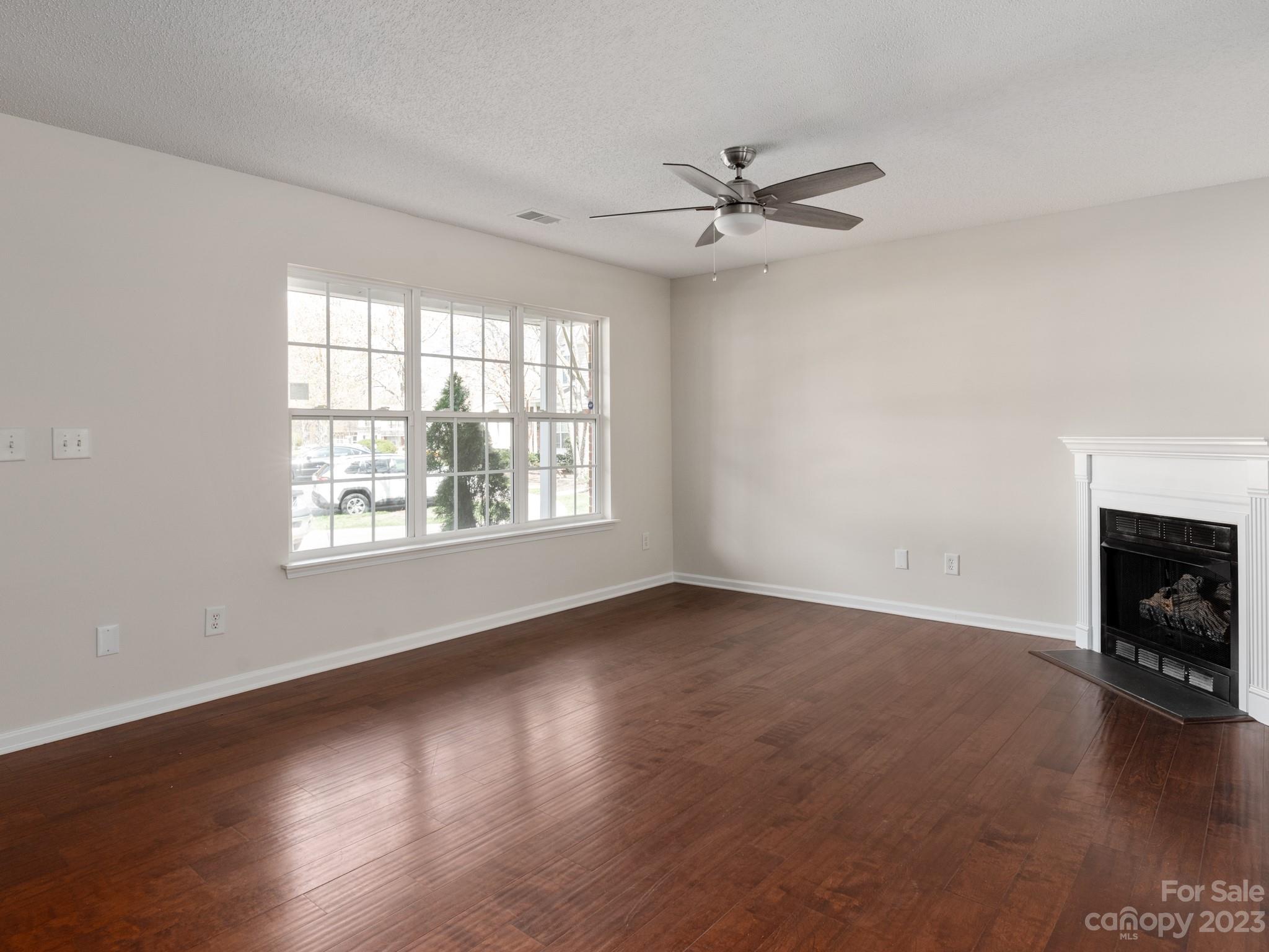 8158 Rudolph Road Charlotte, NC 28216 - Photo 3 of 23 an empty room with windows fireplace and wooden floor