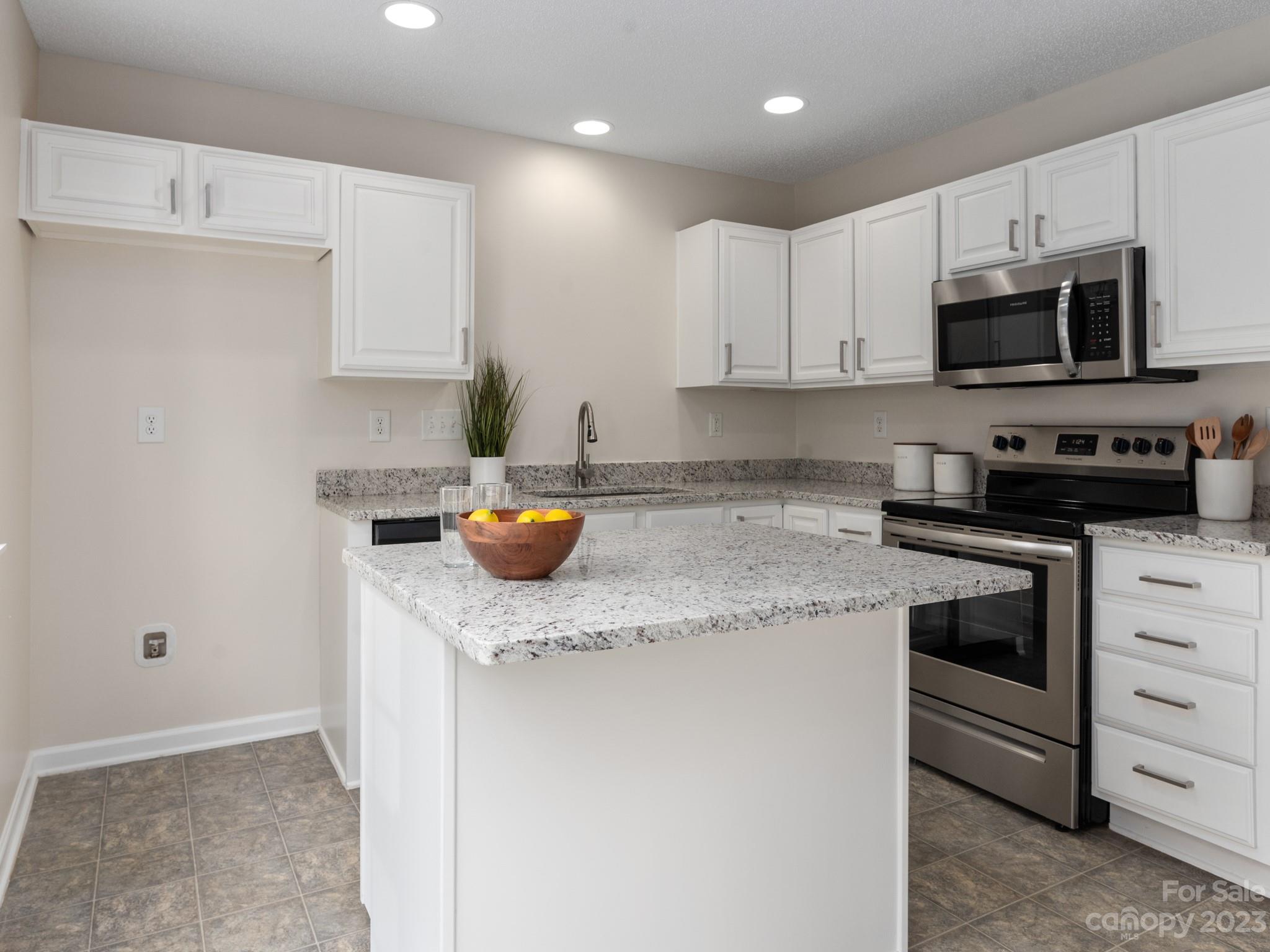 8158 Rudolph Road Charlotte, NC 28216 - Photo 7 of 23 a kitchen with stainless steel appliances granite countertop a sink stove and white cabinets