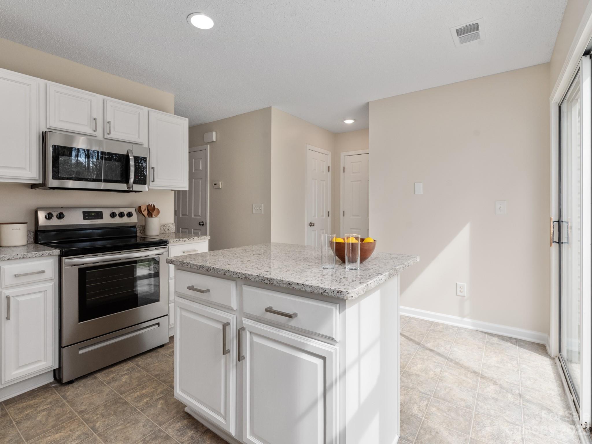 8158 Rudolph Road Charlotte, NC 28216 - Photo 8 of 23 a kitchen with stainless steel appliances granite countertop a stove a microwave and a refrigerator