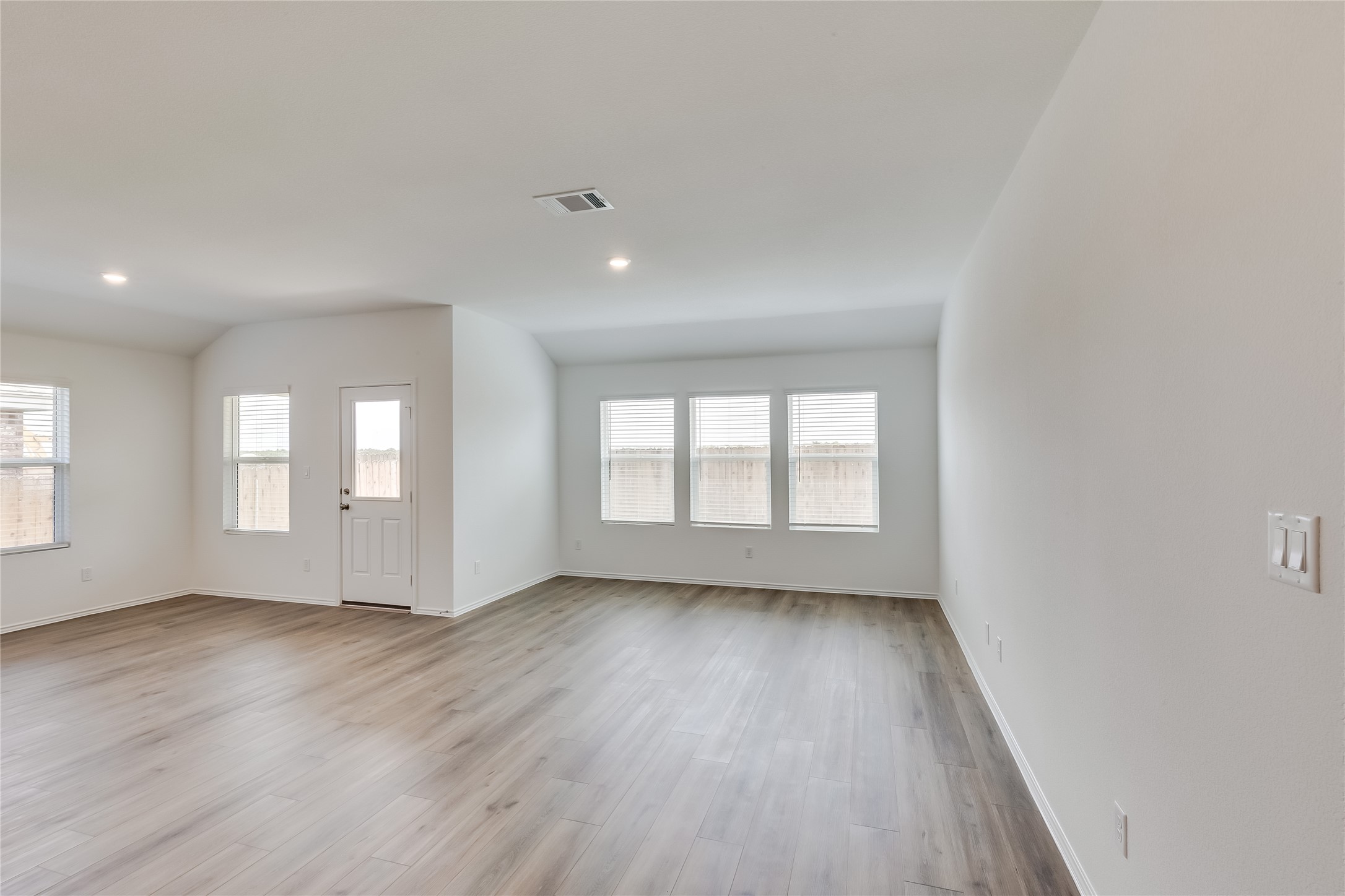2000 Gilmer Way Leander, TX 78641 - Photo 6 of 39 Unfurnished living room with wood finished floors, baseboards, and recessed lighting