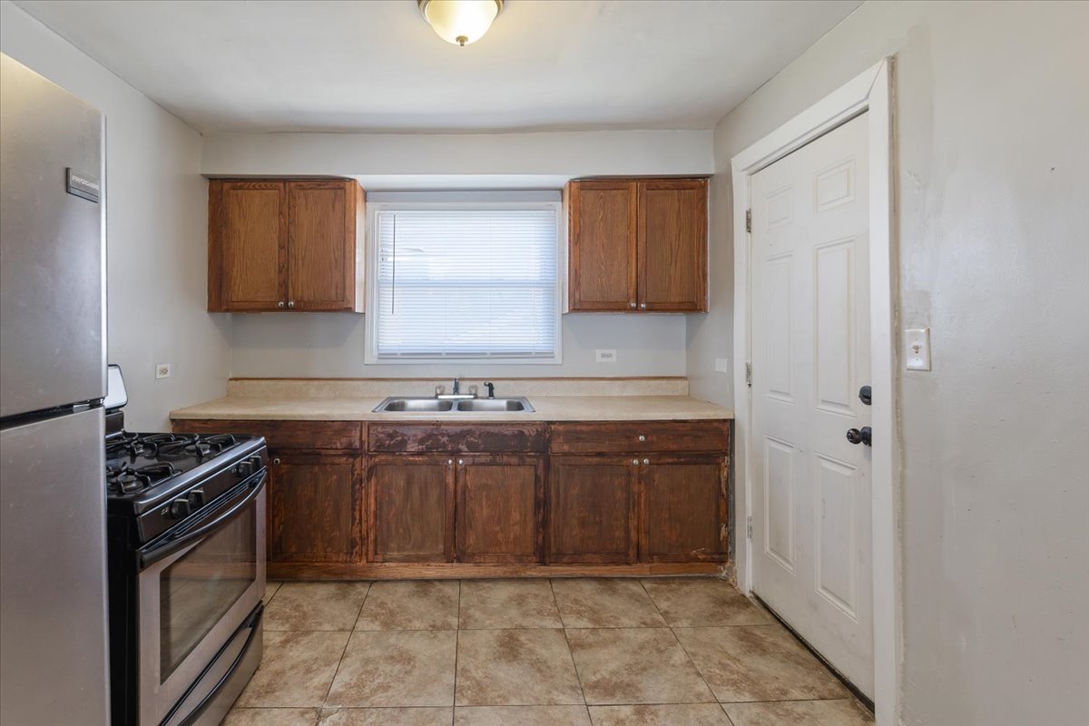 128 North Menard Avenue Chicago, IL 60644 - Photo 9 of 20 a kitchen with stainless steel appliances granite countertop a stove a sink and a refrigerator