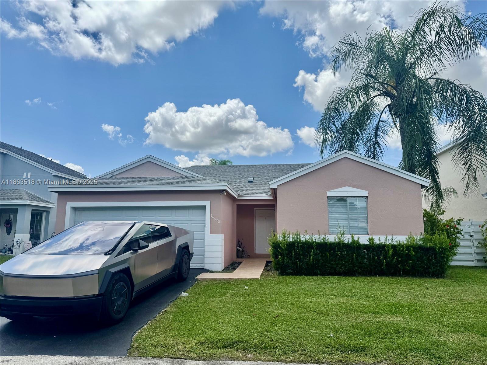 14570 Southwest 145th Place, Unit 14570 Miami, FL 33186 - Photo 1 of 23 a front view of a house with garden