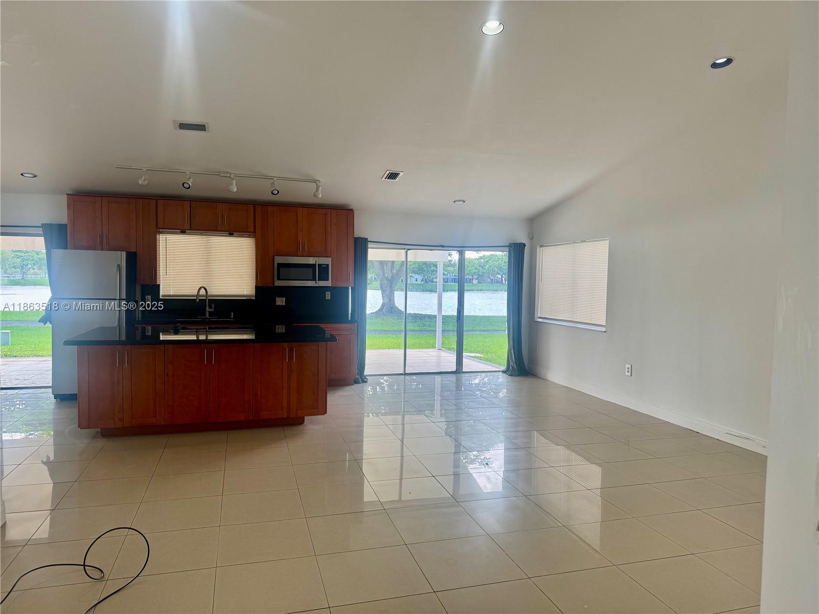 14570 Southwest 145th Place, Unit 14570 Miami, FL 33186 - Photo 13 of 23 a living room with furniture and a flat screen tv