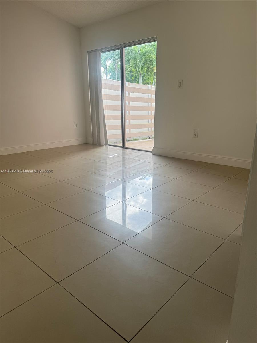 14570 Southwest 145th Place, Unit 14570 Miami, FL 33186 - Photo 4 of 23 an empty room with windows and entrance