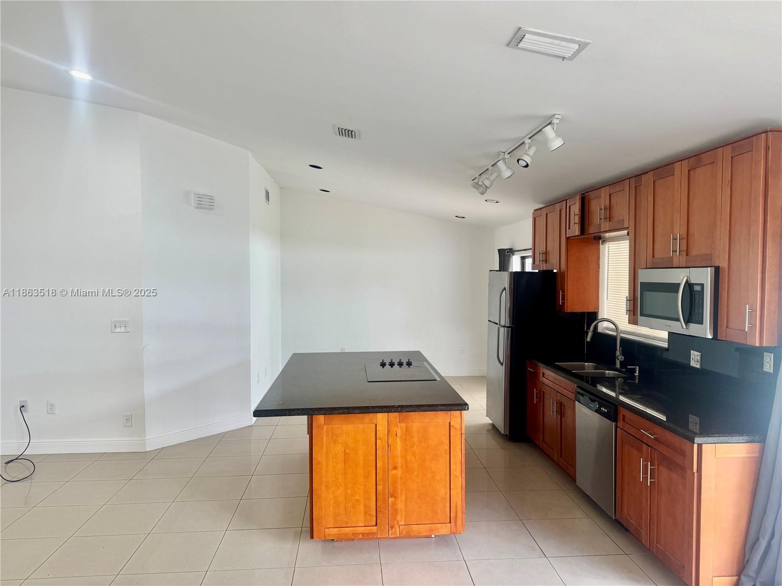 14570 Southwest 145th Place, Unit 14570 Miami, FL 33186 - Photo 7 of 23 a kitchen with stainless steel appliances granite countertop a stove refrigerator and microwave