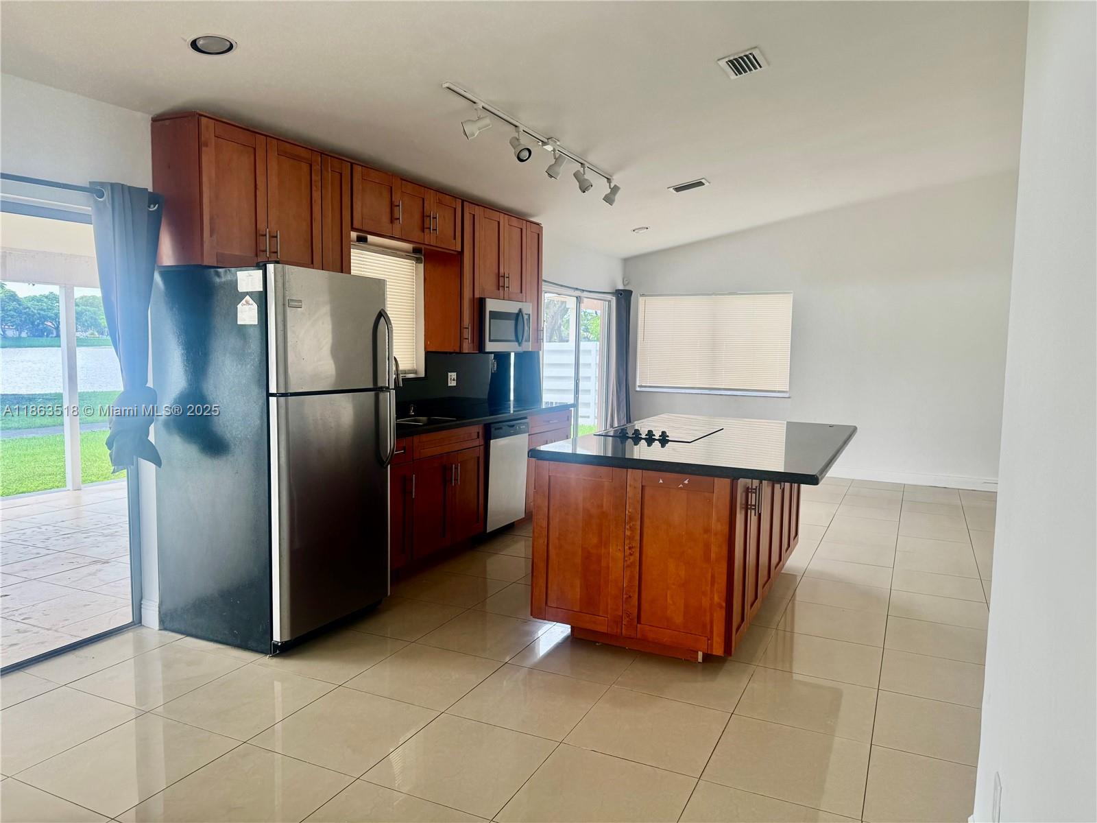 14570 Southwest 145th Place, Unit 14570 Miami, FL 33186 - Photo 9 of 23 a kitchen with stainless steel appliances granite countertop a refrigerator and a sink