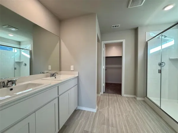 a spacious bathroom with a double vanity sink and mirror