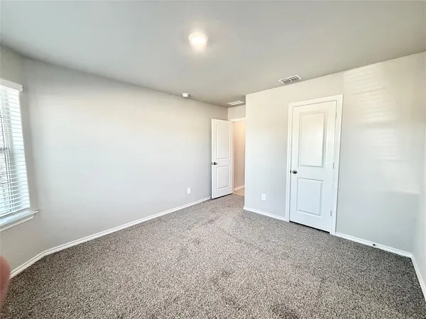an empty room with windows and closet
