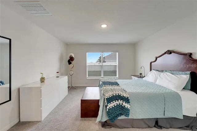 a spacious bedroom with a bed and a cabinets