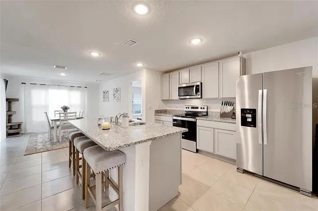 a kitchen with a center island and stainless steel appliances