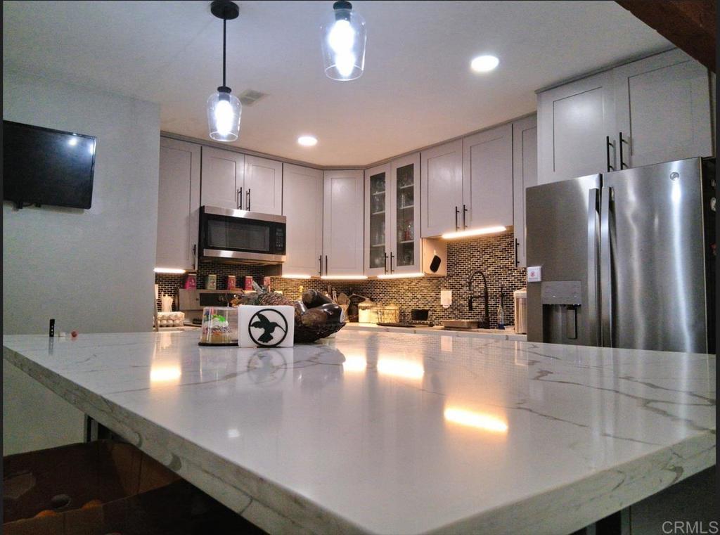 101 Lancer Avenue Oceanside, CA 92058 - Photo 2 of 17 a kitchen with sink a refrigerator and chairs
