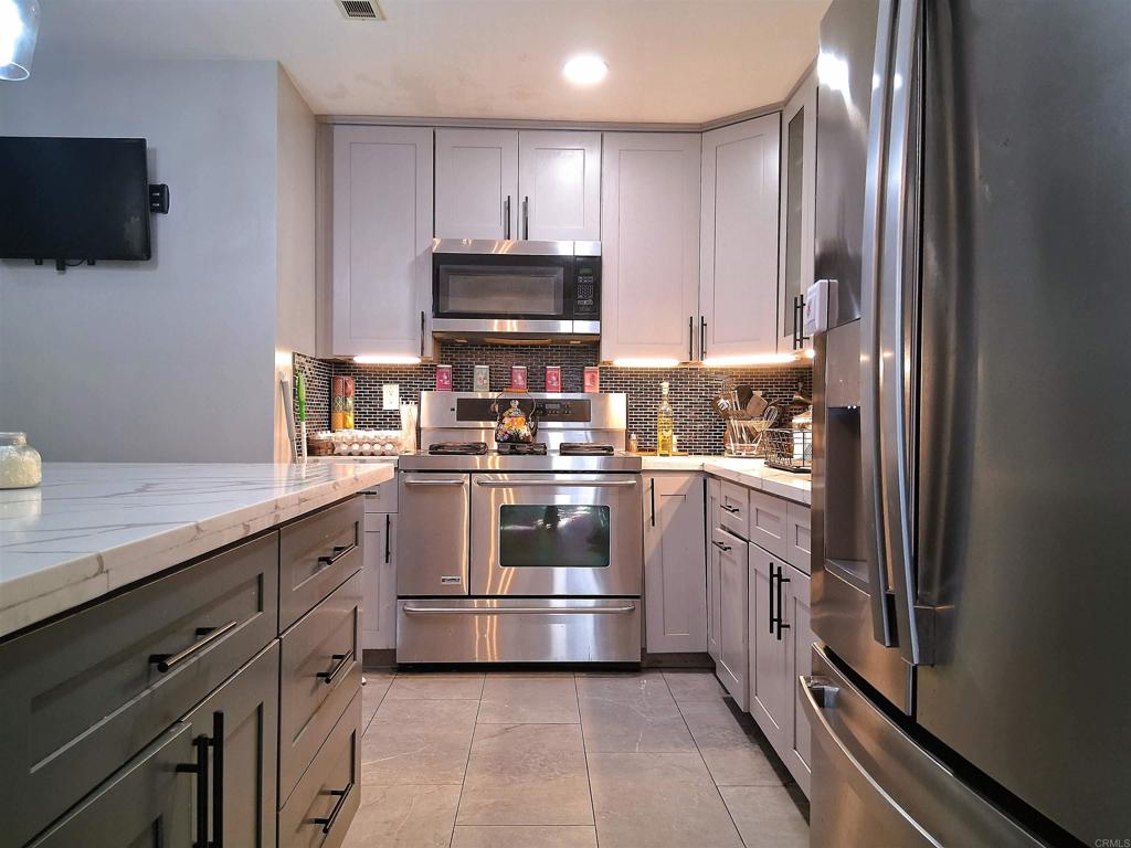 101 Lancer Avenue Oceanside, CA 92058 - Photo 5 of 17 a kitchen with stainless steel appliances granite countertop a refrigerator and a stove top oven
