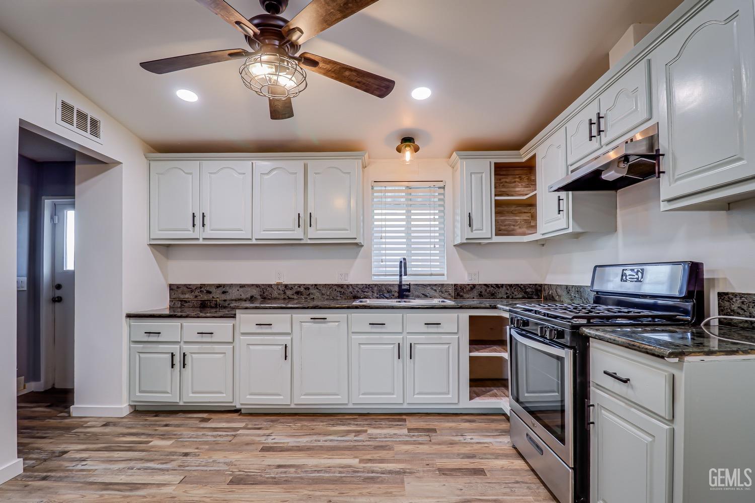 Undisclosed Address Bakersfield, CA 93314 - Photo 11 of 27 a kitchen with stainless steel appliances granite countertop a stove sink and cabinets