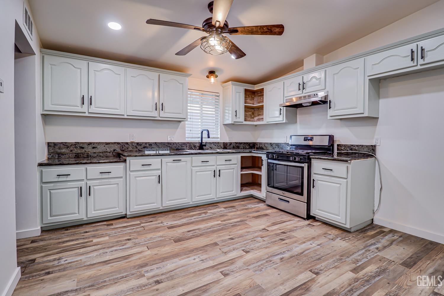 Undisclosed Address Bakersfield, CA 93314 - Photo 13 of 27 a kitchen with stainless steel appliances granite countertop white cabinets a sink a stove a refrigerator and white cabinets