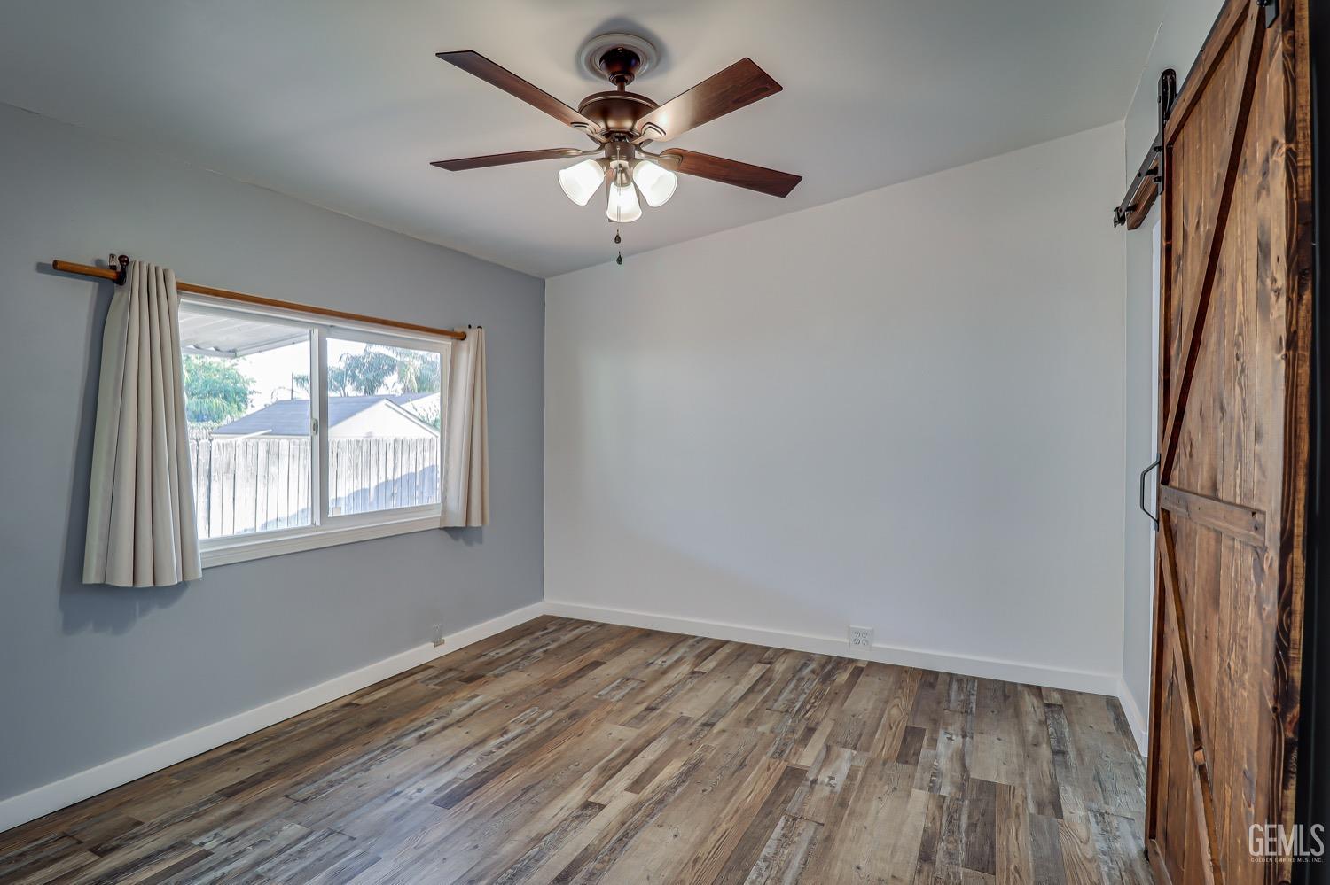 Undisclosed Address Bakersfield, CA 93314 - Photo 19 of 27 an empty room with wooden floor fan and windows