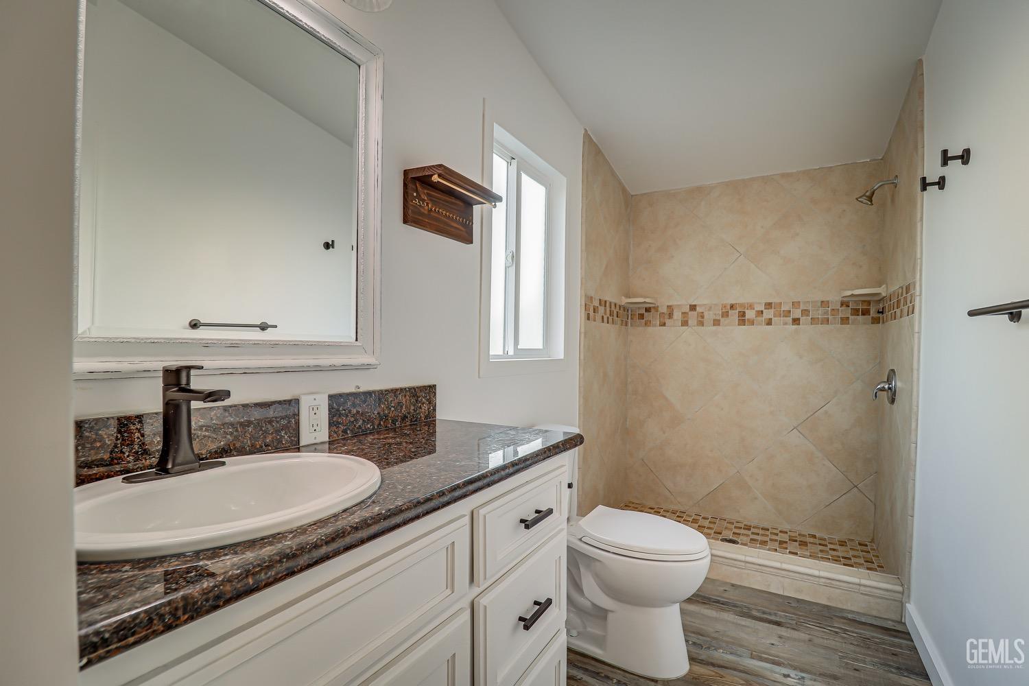 Undisclosed Address Bakersfield, CA 93314 - Photo 21 of 27 a bathroom with a granite countertop sink toilet and shower