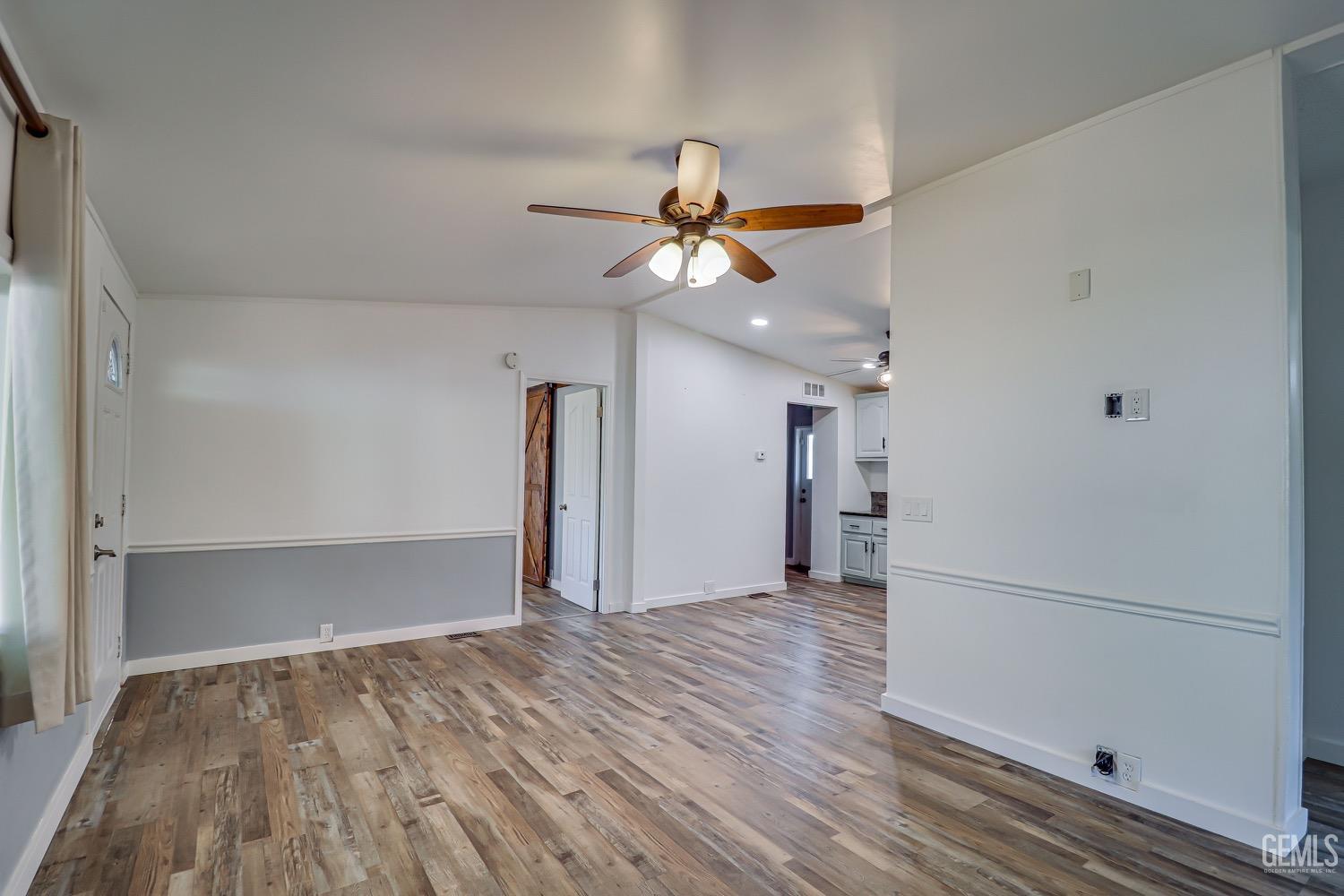 Undisclosed Address Bakersfield, CA 93314 - Photo 9 of 27 a view of a room with wooden floor and a ceiling fan