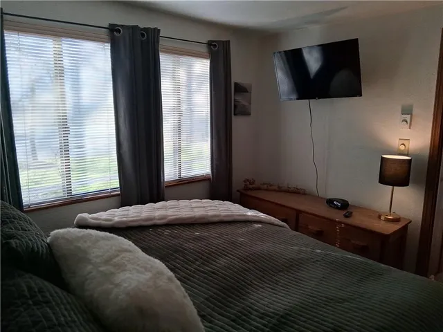 a bedroom with a bed and a flat screen tv