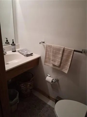 a bathroom with a sink toilet and mirror
