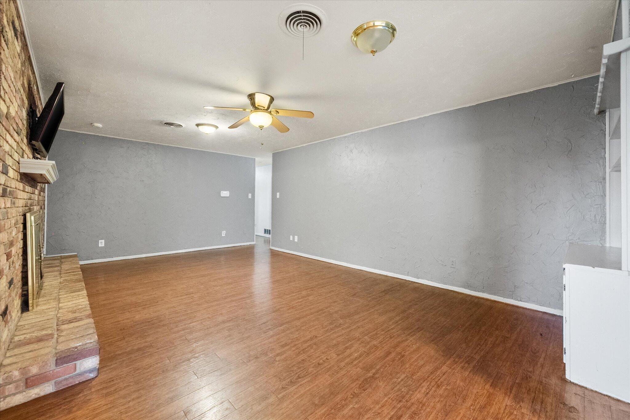 4604 27th Street Lubbock, TX 79410 - Photo 20 of 36 a view of an empty room with a ceiling fan and wooden floor