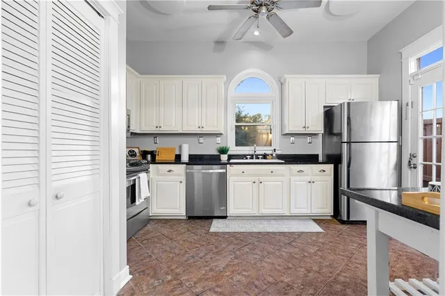 a kitchen with a refrigerator a stove top oven a sink and cabinets
