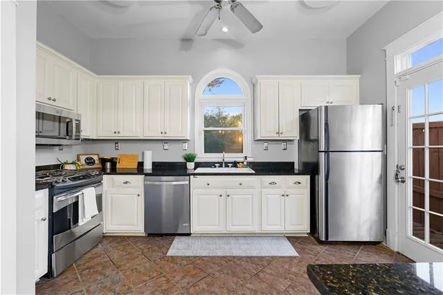 a kitchen with a refrigerator a stove a microwave and cabinets