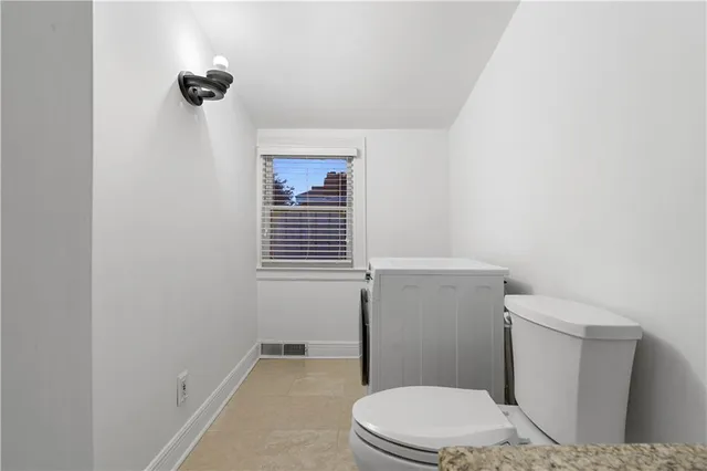a white toilet sitting next to a bathroom sink