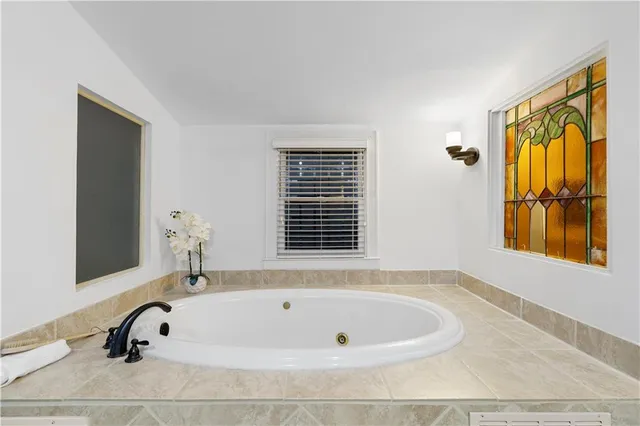 a bathroom with bathtub and window
