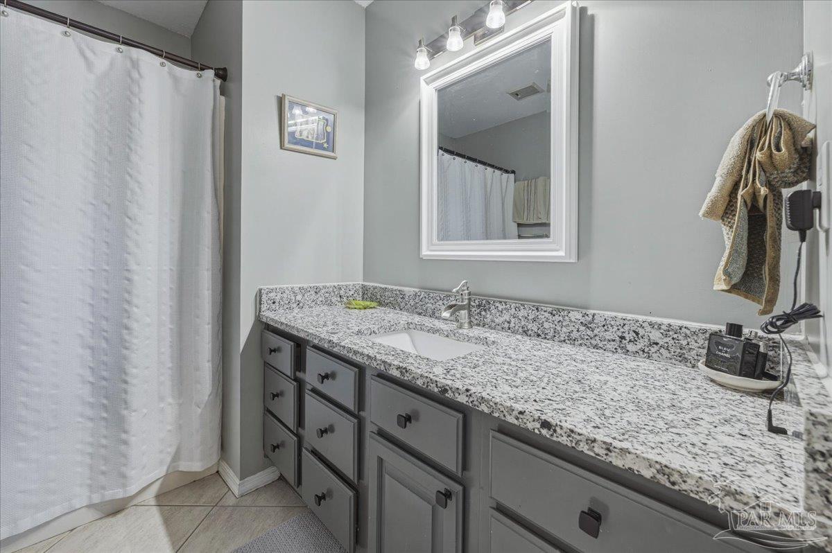 26063 Canal Road, Unit 3F Orange Beach, AL 36561 - Photo 59 of 72 a bathroom with a granite countertop sink and a mirror