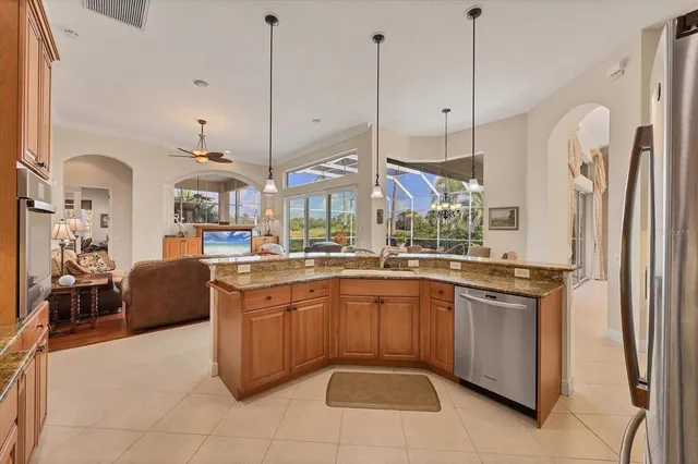 a large kitchen with stainless steel appliances granite countertop a stove a sink and a refrigerator