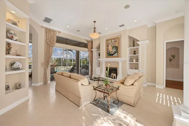 a living room with furniture a fireplace and a chandelier