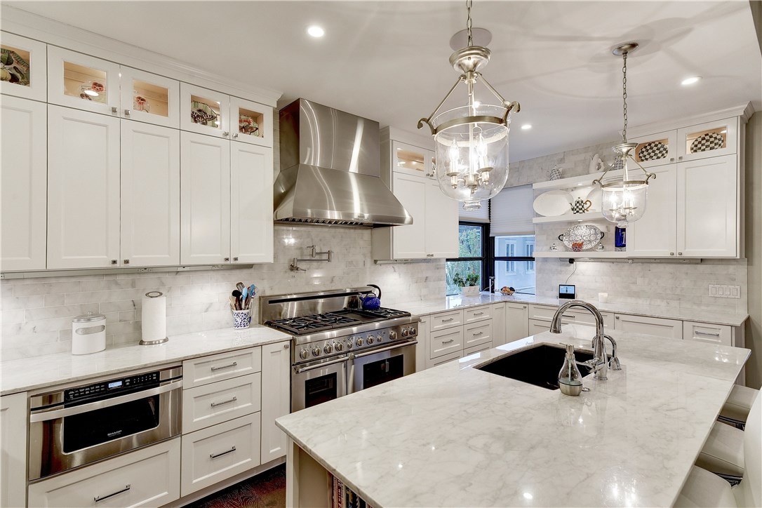 a kitchen with stainless steel appliances a stove a sink a microwave a refrigerator and cabinets