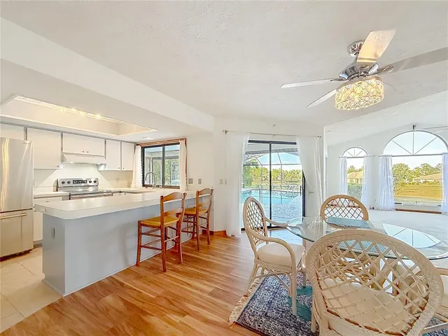a kitchen with granite countertop white cabinets and white stainless steel appliances