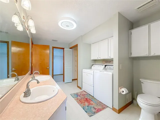 an empty room with wooden floor chandelier fan and windows