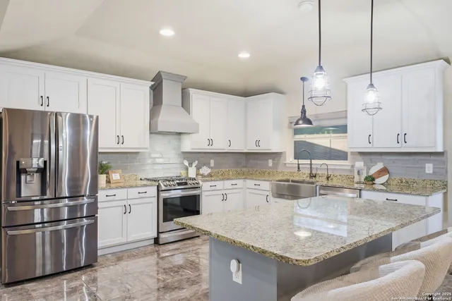 a kitchen with stainless steel appliances granite countertop a sink a stove and a refrigerator