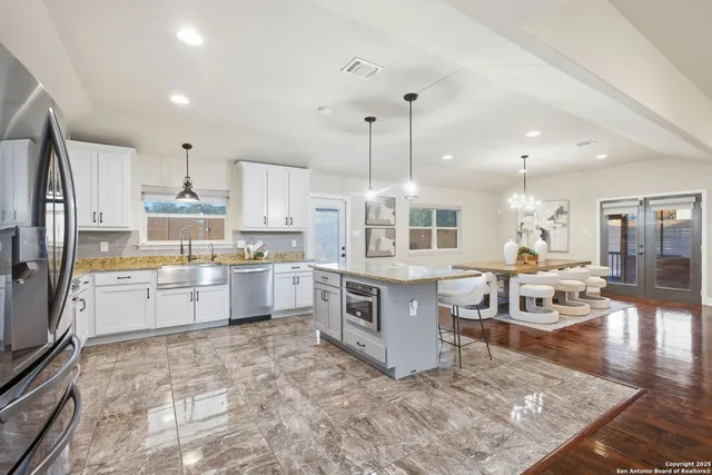 a large kitchen with kitchen island a large counter space stainless steel appliances and cabinets