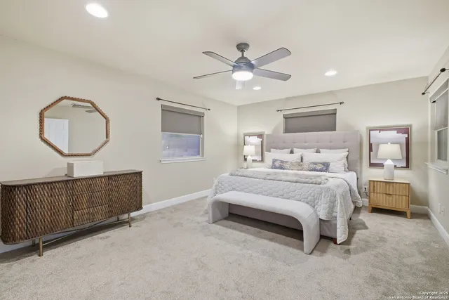 a bedroom with a bed a mirror on dresser and a chandelier