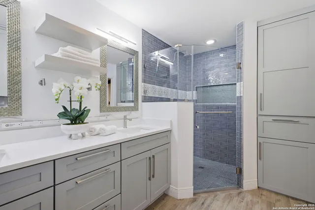 a bathroom with a shower sink and mirror