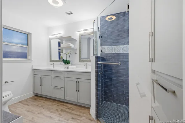 a bathroom with a granite countertop sink mirror and shower