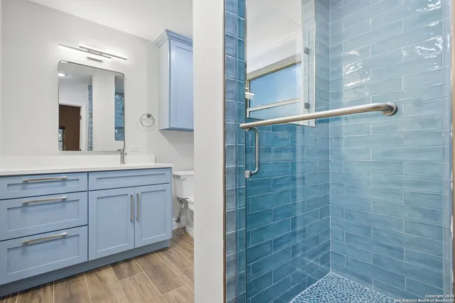 a bathroom with a granite countertop sink a mirror and a shower